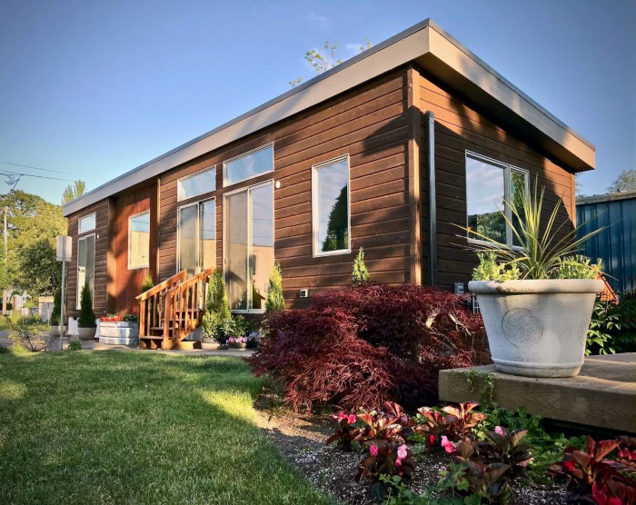 Thiết kế nhà tiền chế giả gỗ có sân vườn cho không gian sống thêm xanh mát.